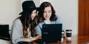two women using a laptop
